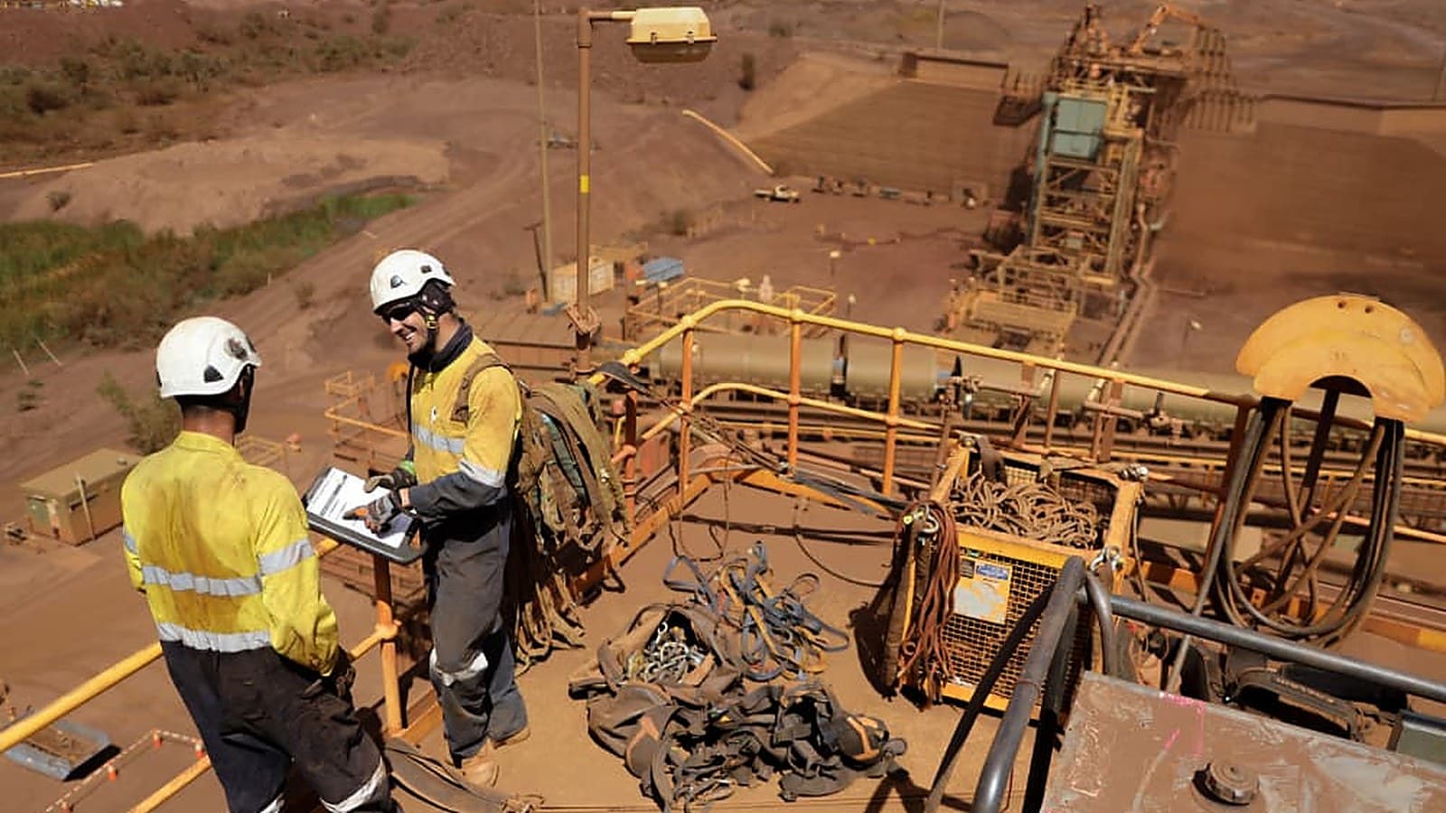 Two mine workers reviewing readings on a tablet at a producing site